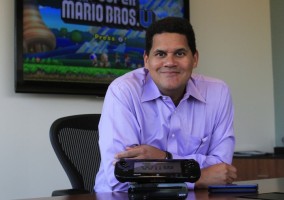 Reggie Fils-Aime con una Wii U y New Super Mario Bros U